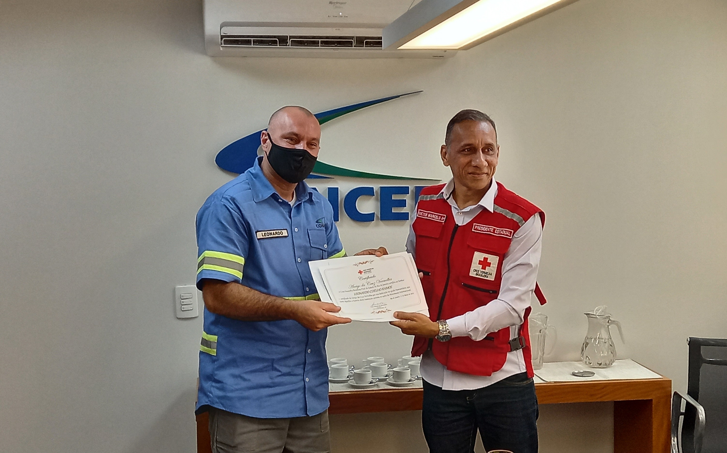 O presidente da Cruz Vermelha entrega certificado de agradecimento a Leonardo